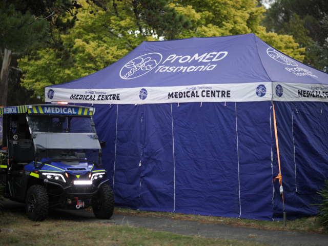 ProMED patient transport buggy beside a branded medical centre marquee