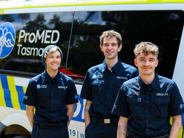 Three ProMED Tasmania medics in front of a ProMED stretcher vehicle