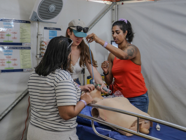 Clinician treating a patient in a field hospital bay
